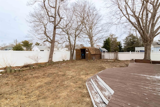 view of yard with a wooden deck and a storage shed