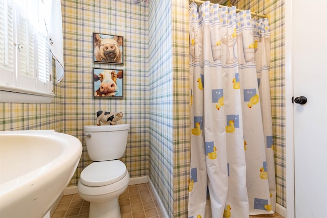 bathroom featuring tile patterned flooring, walk in shower, sink, and toilet