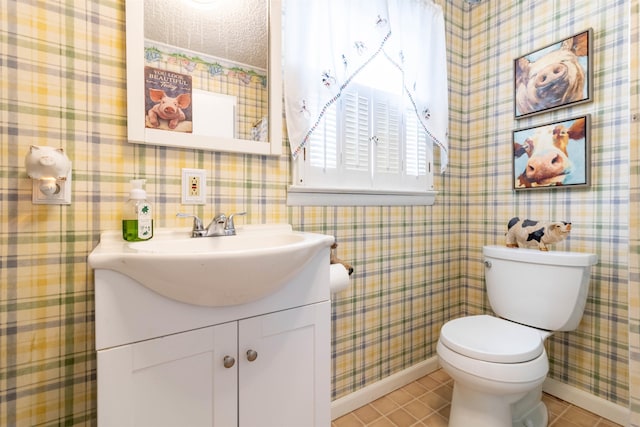 bathroom featuring vanity, tile patterned flooring, a textured ceiling, and toilet