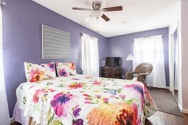 bedroom featuring hardwood / wood-style floors, a textured ceiling, and ceiling fan