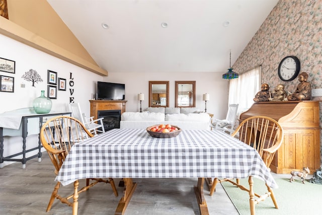 dining area featuring high vaulted ceiling and light hardwood / wood-style floors