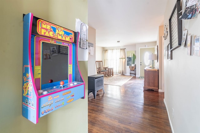 playroom featuring hardwood / wood-style floors and a wood stove