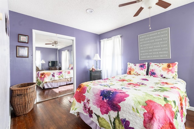 bedroom featuring ceiling fan, dark hardwood / wood-style floors, and a textured ceiling