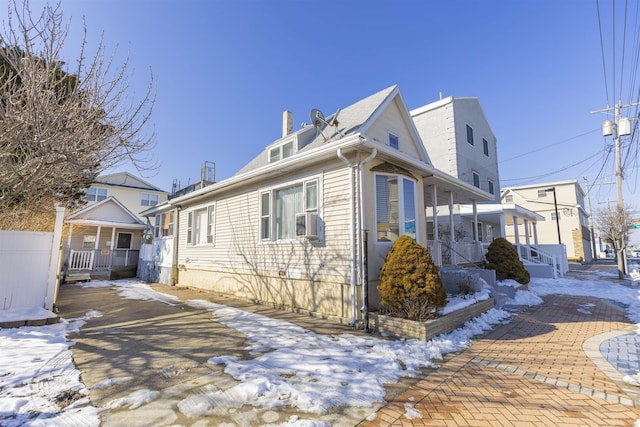 snow covered property with a porch