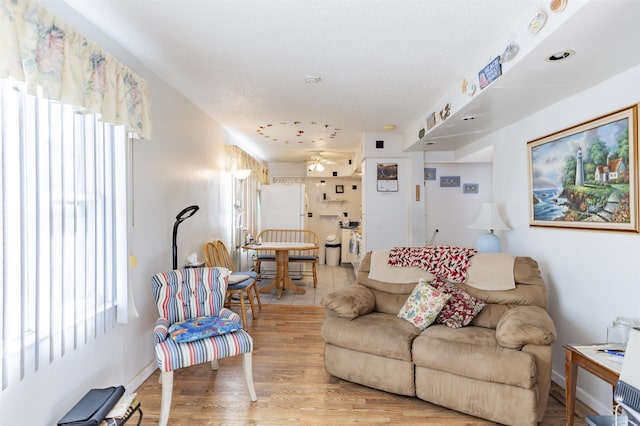 living room featuring ceiling fan and light hardwood / wood-style floors