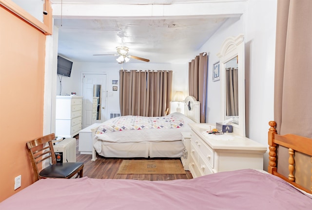 bedroom with ceiling fan, radiator, and hardwood / wood-style flooring