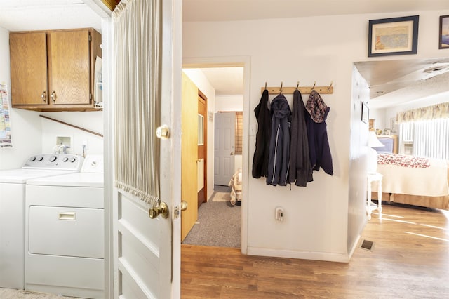 interior space featuring washing machine and dryer, cabinets, and wood-type flooring