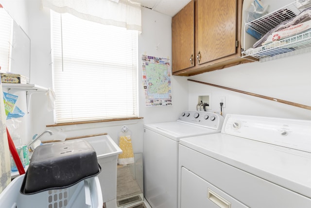 laundry area featuring washer and dryer and cabinets