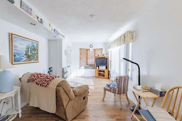 living room with wood-type flooring and a textured ceiling