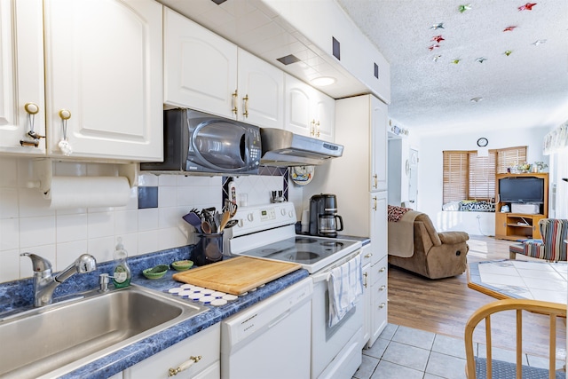 kitchen with tasteful backsplash, sink, white appliances, white cabinetry, and a textured ceiling