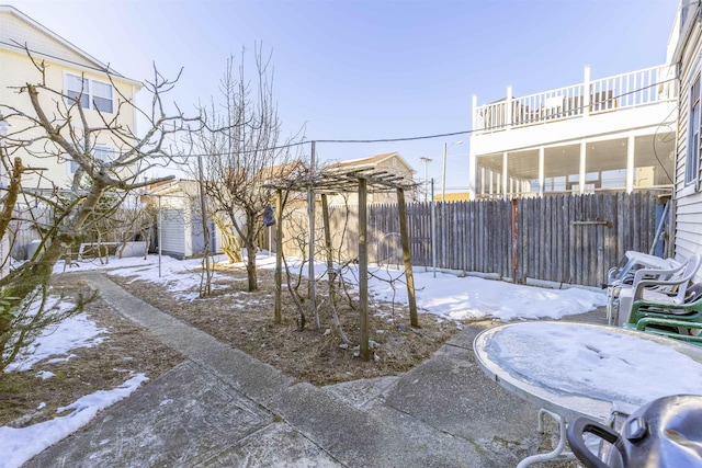 yard covered in snow featuring a balcony