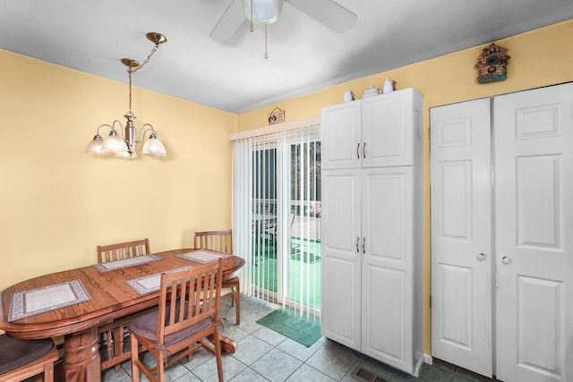 dining area featuring light tile patterned floors and ceiling fan with notable chandelier