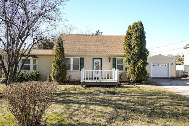 view of front of property featuring roof with shingles, a front lawn, an outdoor structure, concrete driveway, and a detached garage