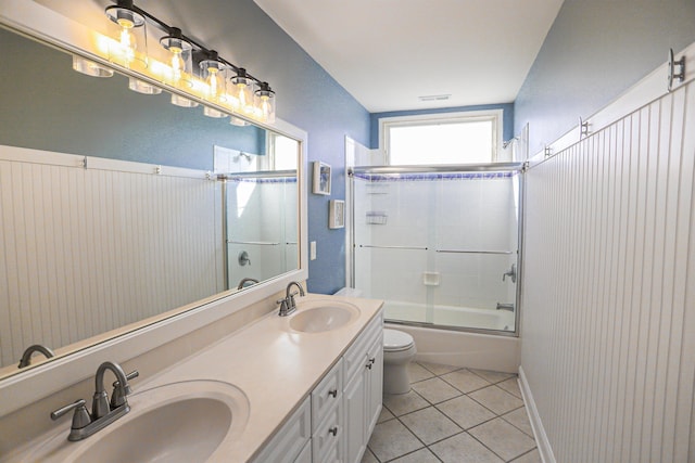 full bathroom with tile patterned floors, vanity, enclosed tub / shower combo, and toilet