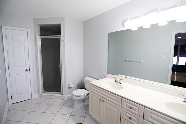 bathroom with tile patterned floors, a shower with door, vanity, and toilet