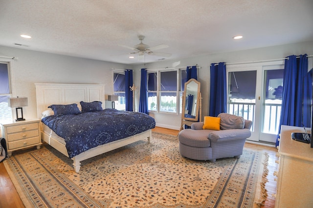 bedroom with ceiling fan, wood-type flooring, a textured ceiling, and access to outside