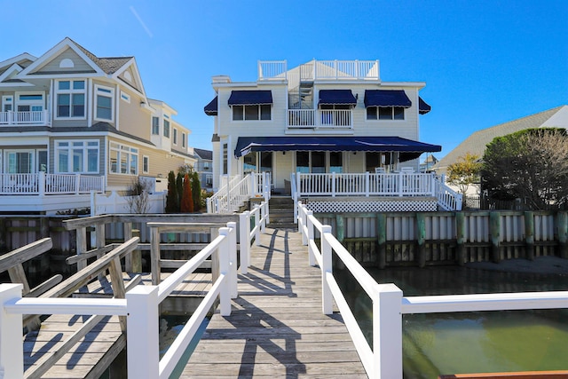 back of property featuring a water view and a balcony