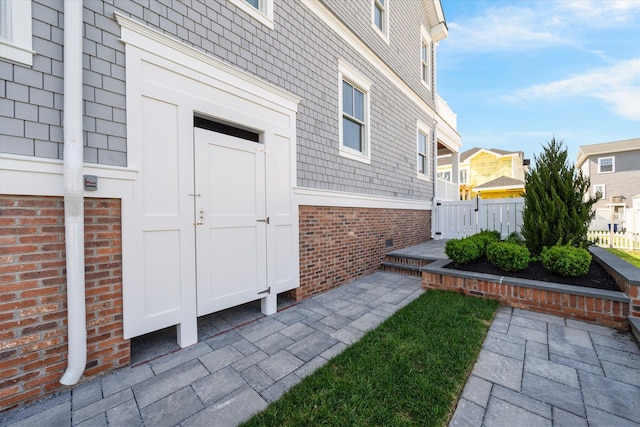 283 85th St, Stone Harbor, NJ 08247 - view of exterior entry with brick siding, fence, a gate, and a residential view