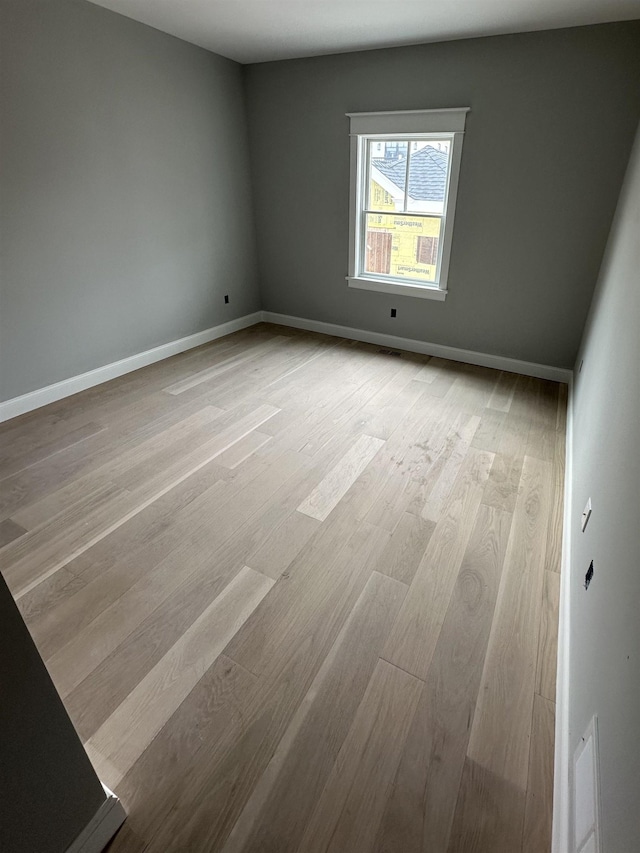 unfurnished room featuring light wood finished floors and baseboards