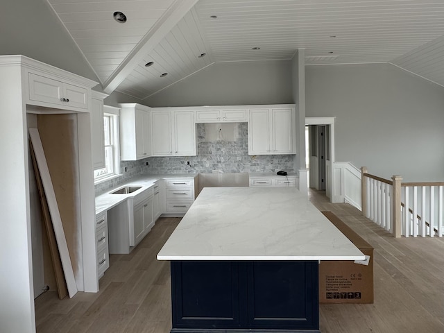 kitchen with tasteful backsplash, light wood-style floors, and vaulted ceiling