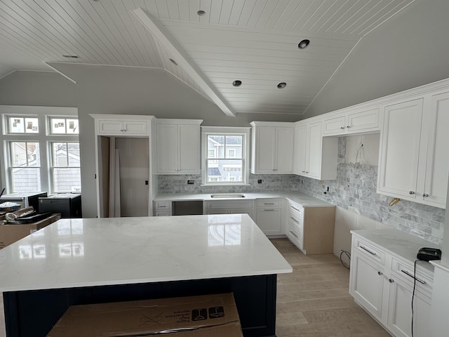 kitchen with decorative backsplash, lofted ceiling, wooden ceiling, and a center island