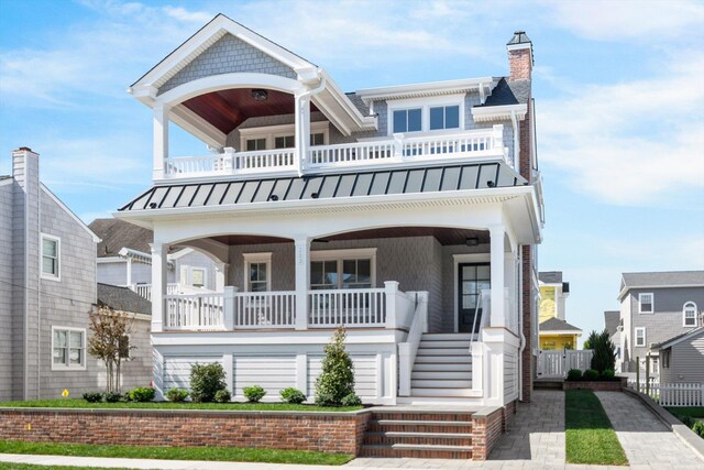 283 85th St, Stone Harbor, NJ 08247 - view of front of home featuring a standing seam roof, a balcony, covered porch, a chimney, and stairs