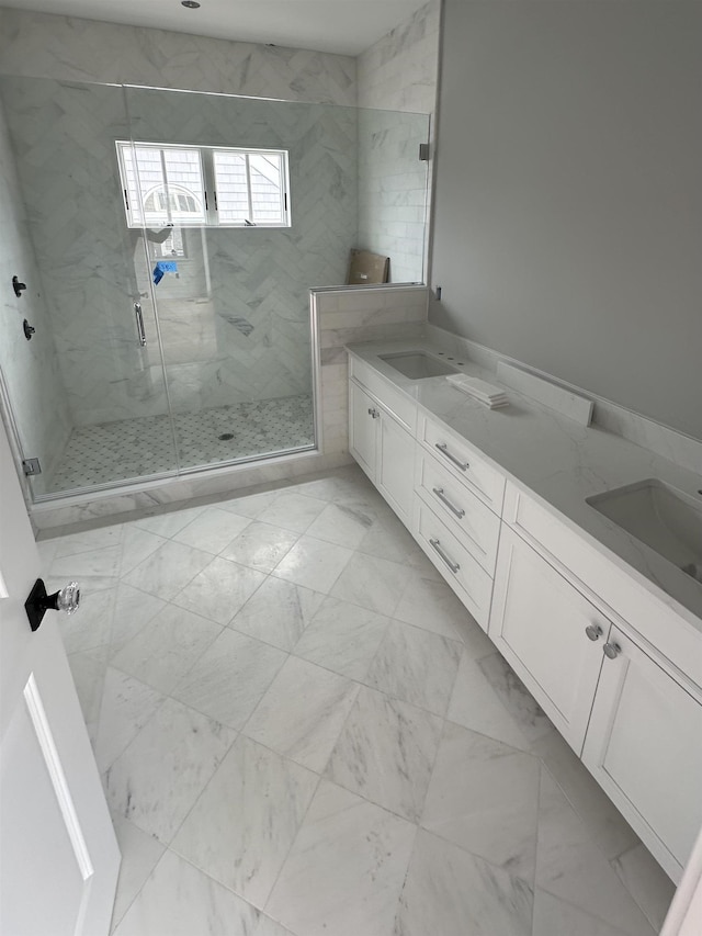 bathroom with a sink, marble finish floor, double vanity, and a shower stall