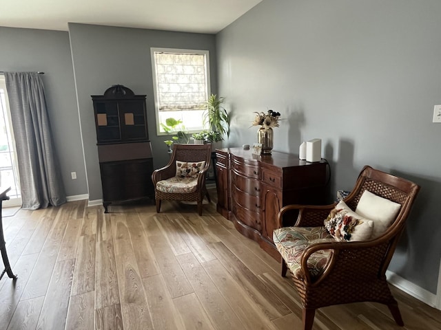 living area with light wood-type flooring and baseboards
