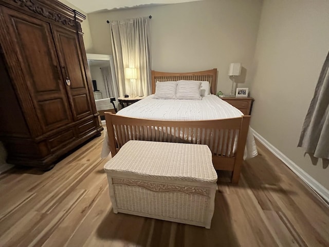 bedroom with light wood-type flooring and baseboards