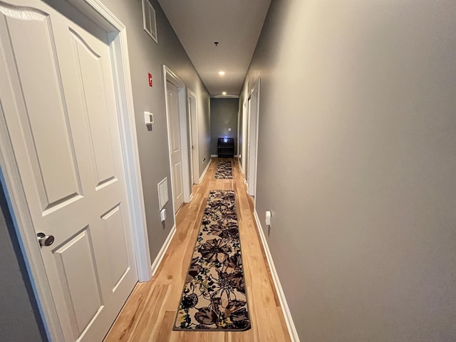 hall with light wood-style flooring, recessed lighting, and baseboards