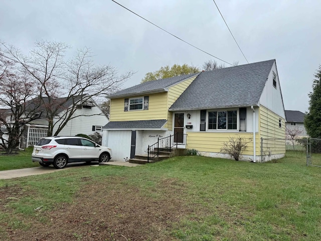 split level home with a front yard, a garage, driveway, roof with shingles, and fence