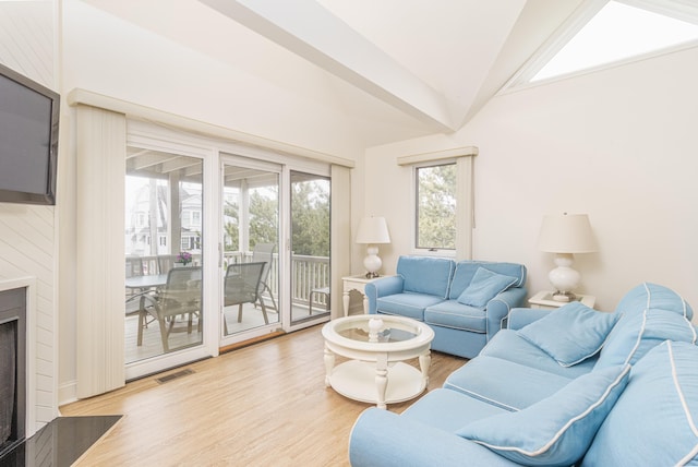 7889 Sunset Dr N, Unit North, Avalon, NJ 08202 - living area with light wood-type flooring, vaulted ceiling, and a fireplace