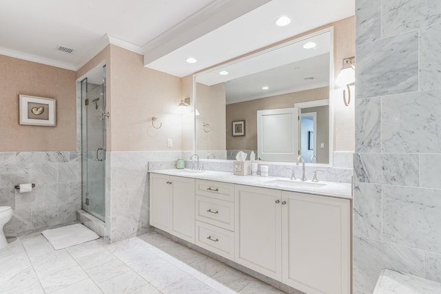 bathroom with tile walls, a shower with door, ornamental molding, and vanity