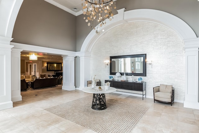 foyer entrance with a towering ceiling, decorative columns, arched walkways, and ornamental molding