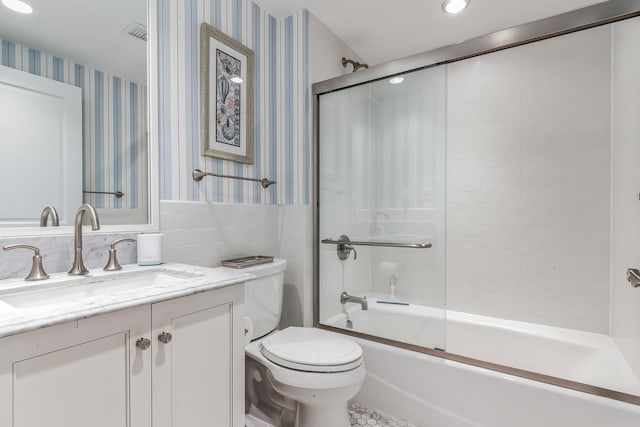 full bathroom featuring combined bath / shower with glass door, vanity, and toilet