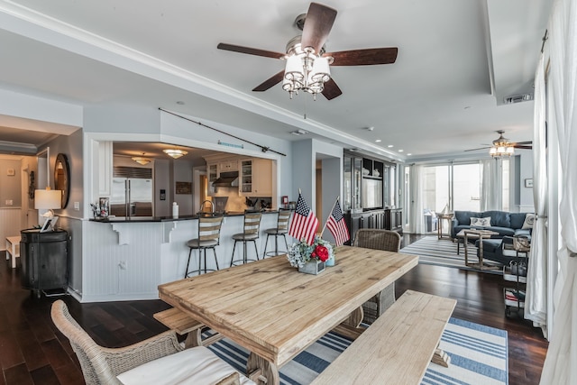 dining area featuring ceiling fan, dark wood-type flooring, and ornamental molding