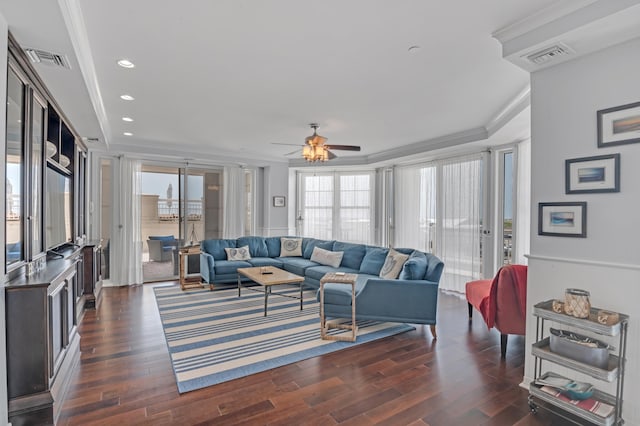 living room featuring a healthy amount of sunlight, dark wood-type flooring, and crown molding