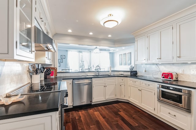 kitchen featuring stainless steel appliances, backsplash, dark hardwood / wood-style flooring, white cabinets, and sink