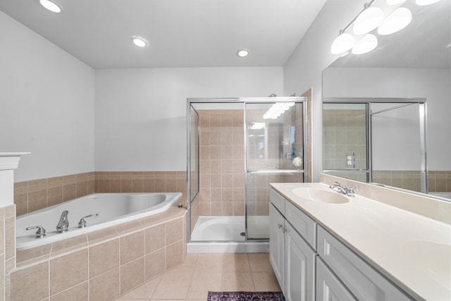 bathroom with a garden tub, double vanity, a sink, a shower stall, and tile patterned flooring