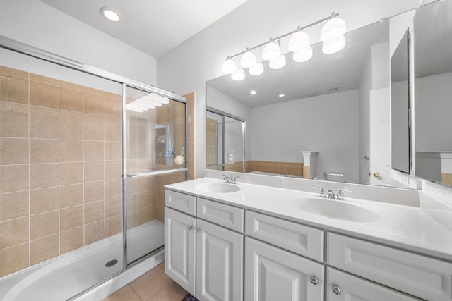 full bathroom featuring a shower stall, a sink, and tile patterned floors