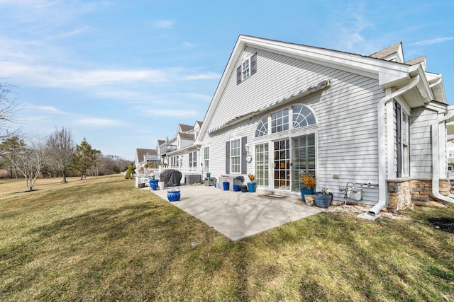 back of property with a lawn and a patio