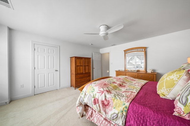 carpeted bedroom with a ceiling fan, visible vents, and baseboards