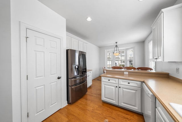 kitchen featuring white cabinets, dishwasher, stainless steel fridge with ice dispenser, light wood-style flooring, and a peninsula