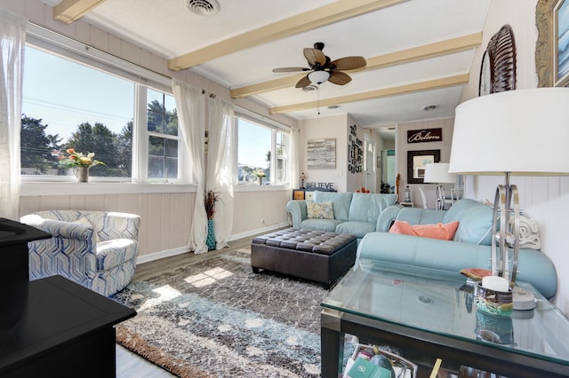 living room featuring ceiling fan, beamed ceiling, and hardwood / wood-style flooring