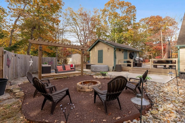 view of patio featuring a storage unit, an outdoor fire pit, and a wooden deck