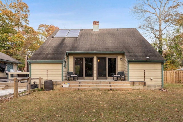 back of house featuring solar panels and a yard