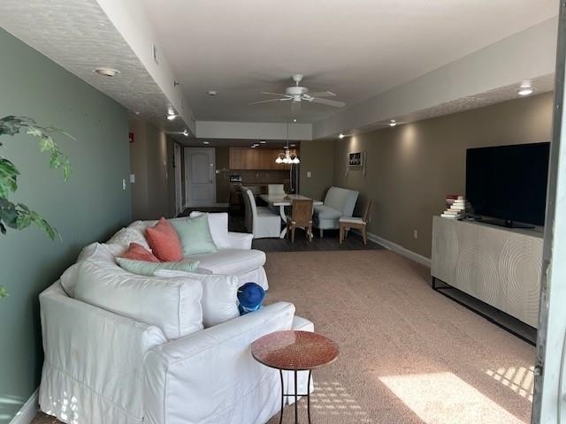 living room with carpet flooring, ceiling fan, and baseboards