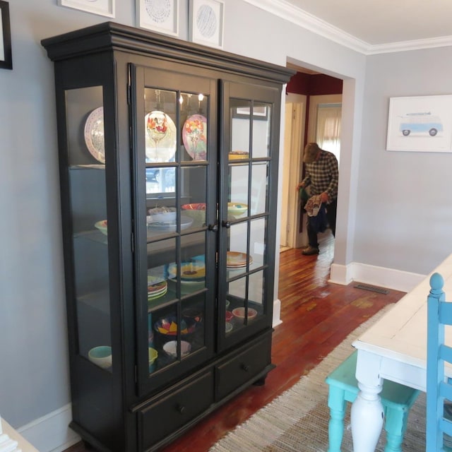 interior space featuring ornamental molding, dark wood finished floors, and baseboards