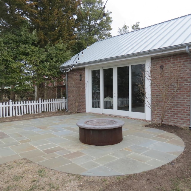 view of patio / terrace with an outdoor fire pit, fence, and french doors