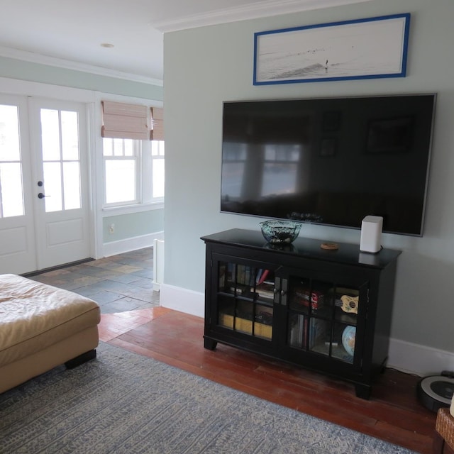 living room featuring baseboards, crown molding, and wood finished floors